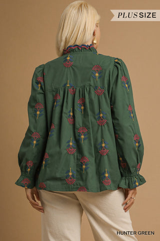 Green blouse with floral patterns on a beige background