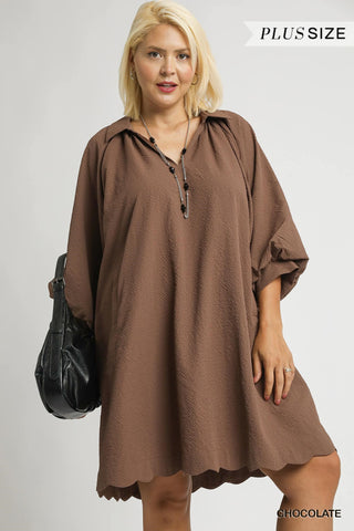 Woman wearing a brown dress with a black bag on a white background