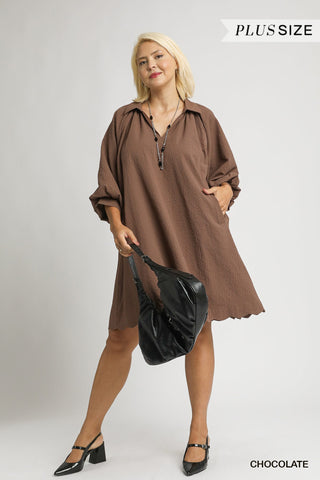 Woman wearing a brown dress holding a black handbag on a white background