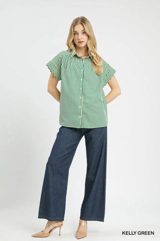 Woman wearing a green and white striped shirt and blue pants on a white background