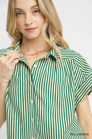 Woman wearing a green and white striped shirt on a plain background