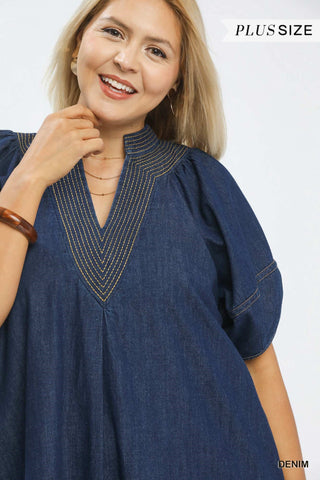 Woman wearing a blue denim dress on a white background