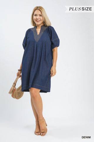 Woman wearing a blue denim dress on a white background