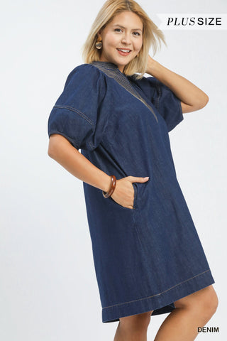 Woman wearing a blue denim dress on a white background