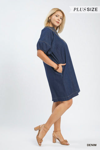 Woman wearing a blue denim dress on a white background with 'Plus Size' text.