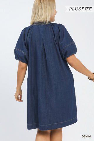 Woman wearing a blue denim dress on a white background