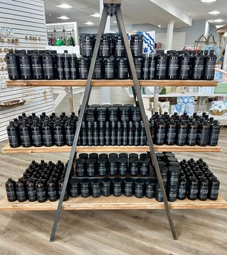 Display of black containers on wooden shelves in a store setting
