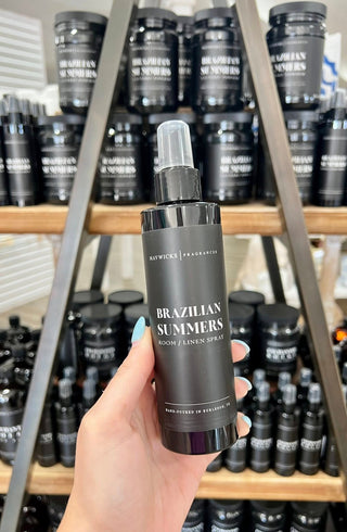 Hand holding a 'Brazilian Summers' product with shelves of similar products in the background