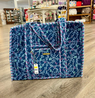 Blue patterned tote bag with a visible tag on a wooden floor.