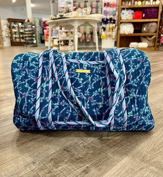 Blue floral-patterned bag on a wooden floor with a store interior in the background
