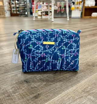 Blue floral patterned bag with a tag on a wooden floor