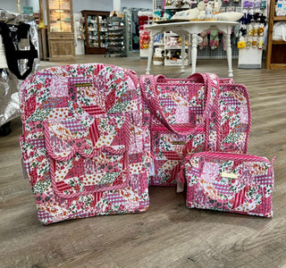 Set of pink patchwork bags on a wooden floor with a store in the background