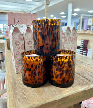 Leopard print candles in gift boxes on a wooden surface