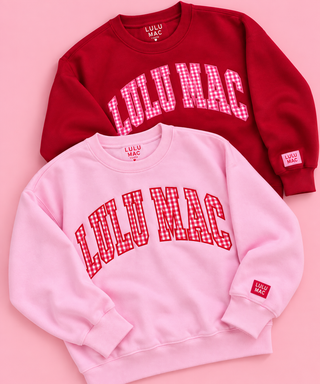 a pink crewneck sweatshirt with 'LULU MAC' printed in red and white gingham lettering