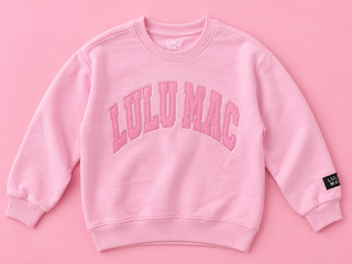 light pink crewneck sweatshirt with 'LULU MAC' printed in pink arched letters across the chest