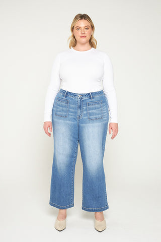 Woman wearing blue jeans and a white top on a white background