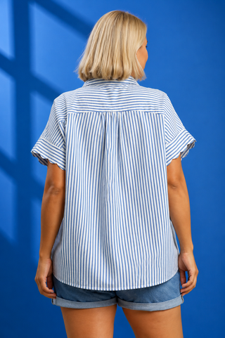 A woman modeling a short-sleeve button-up shirt with vertical blue and white stripes