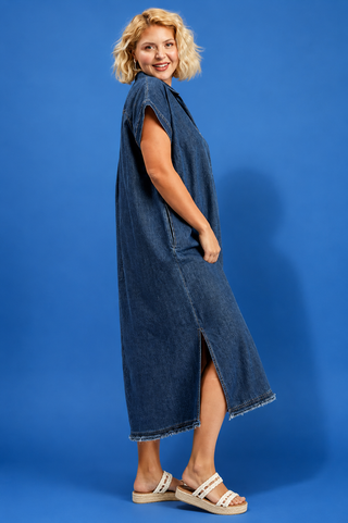 Woman wearing a denim dress against a blue background