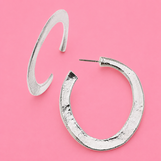 Silver hoop earrings on a pink background