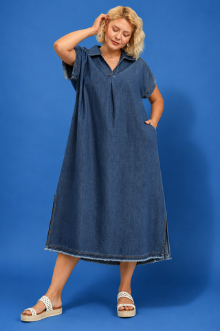 Woman wearing a blue denim dress against a blue background
