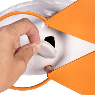 Hand plugging an orange cable into a white electrical outlet.