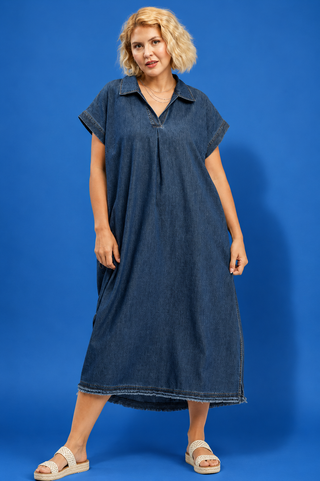Woman wearing a blue denim dress against a blue background