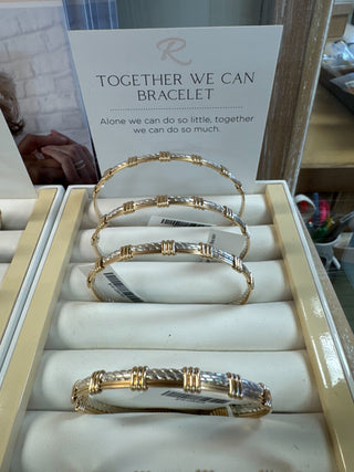 Gold bracelets displayed in a box with a motivational message in the background.