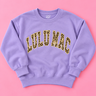 bold vertical leopard print applique lettering outlined in coordinating embroidery on a soft lavender