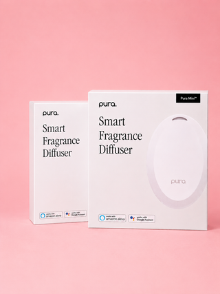 Two boxes of pura Smart Fragrance Diffuser on a pink background