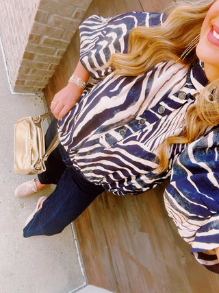 ebra Print Mock Neck Navy Top featuring a chic mock neckline, zebra print, and lightweight woven fabric.