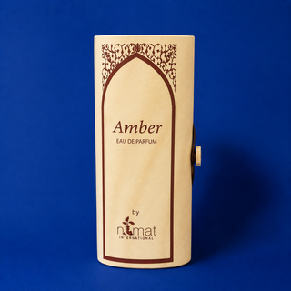 Wooden box for Amber Eau de Parfum by Numat International on a blue background