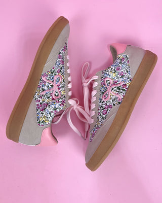 Floral patterned shoes with pink ribbons on a pink background