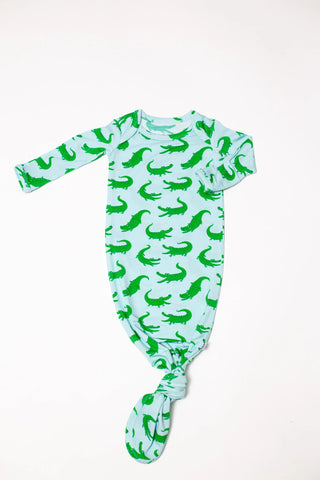 Baby onesie with green alligator pattern on a white background