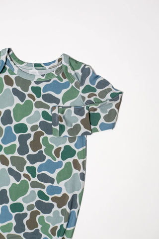 Baby onesie with a pattern of green, blue, and gray shapes on a white background