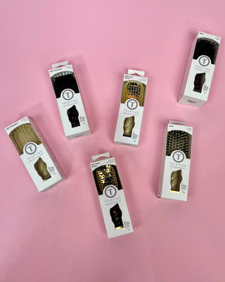Set of hairbrush packaging boxes on a pink background