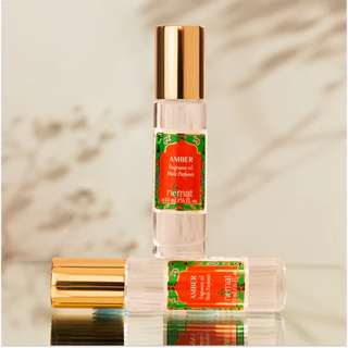 Nemat Amber fragrance oil roll-on in a clear glass bottle with a decorative red and green label and gold cap.