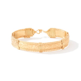 Gold bracelet with intricate design on a white background