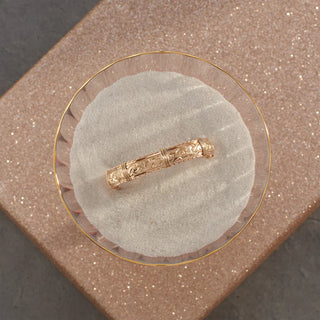 Gold ring on a round stone surface with a textured brown background