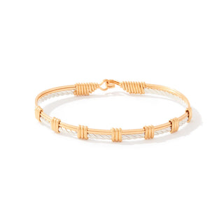 Gold and white braided bracelet on a white background