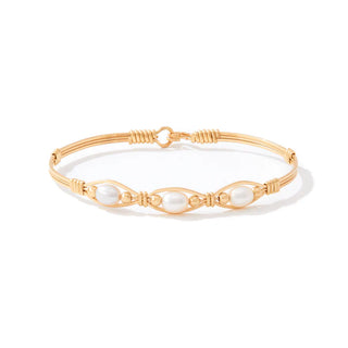Gold bracelet with pearl-like beads on a white background