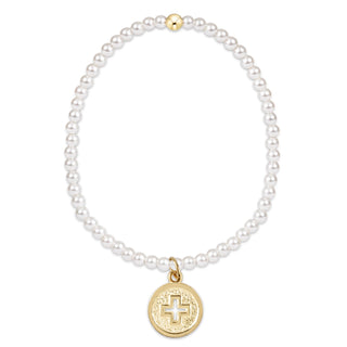 Pearl bracelet with a gold charm featuring a cross on a white background