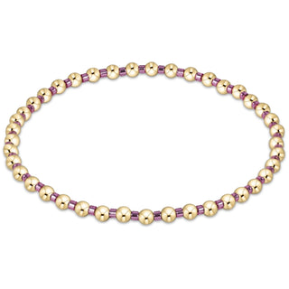 Gold and purple beaded necklace on a white background