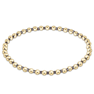 Bracelet with alternating gold and dark beads on a white background