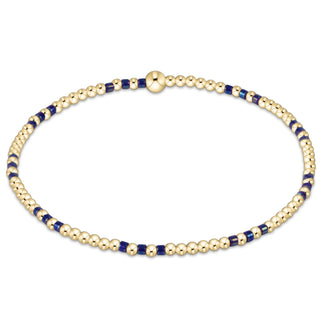 Gold and blue beaded bracelet on a white background