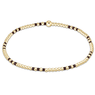Gold and black beaded necklace on a white background