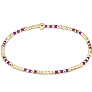 Gold and purple beaded necklace on a white background
