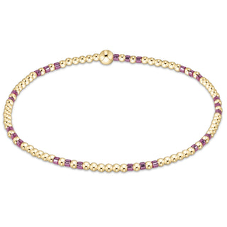 Gold and purple beaded bracelet on a white background
