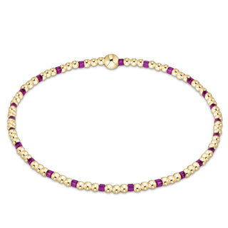 Gold and purple beaded necklace on a white background