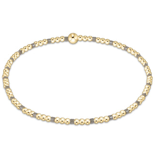 Necklace with alternating gold and gray beads on a white background