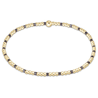 Gold and black beaded necklace on a white background